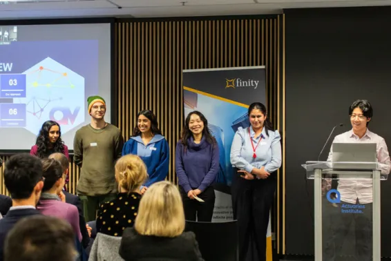 Young people in a group at front of room presenting 