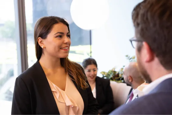Young business woman in black jacket and light apricot v necked blouse looking up and smiling