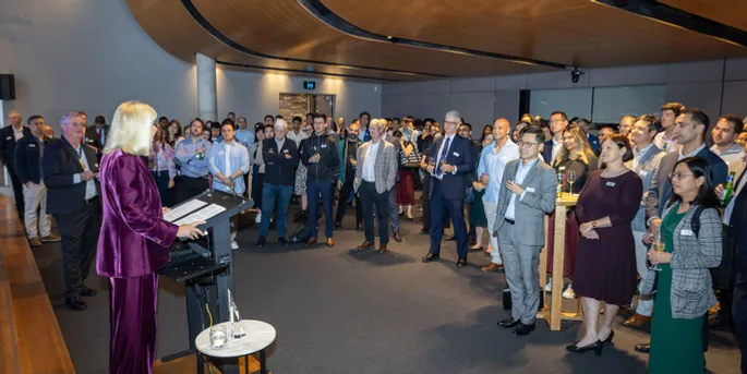 2024 Actuary of the Year winner speaking to a crowd at a venue with large curved timber ceiling