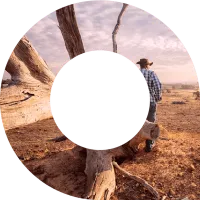 Farmer leaning against a tree in drought within viewfinder shape