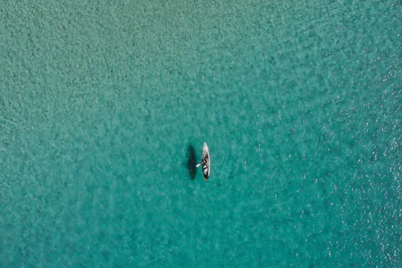 Paddle boarder in middle of beautiful blue ocean