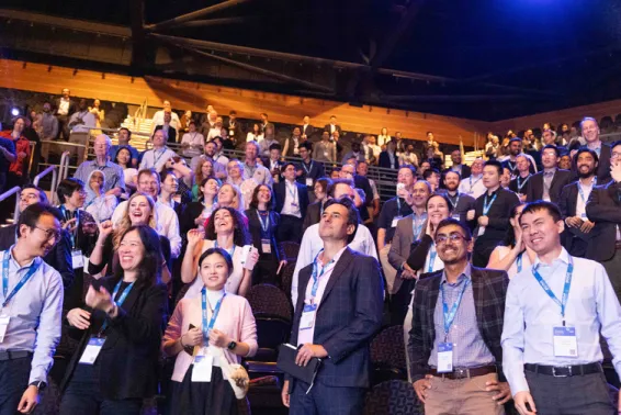 People smiling and laughing, standing in an auditorium