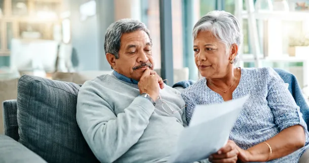 Shot of a mature couple looking worried while going through paperwork together at home.