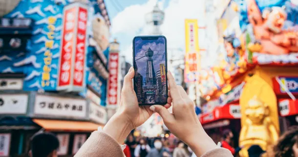 Close-up of a smartphone screen capturing the sights of Tsutenkaku in Osaka