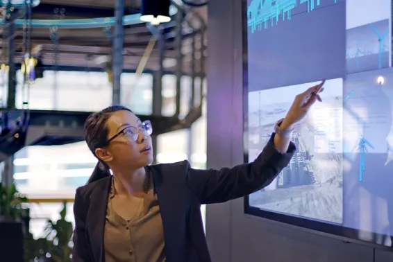 Woman in banking pointing to a screen with data