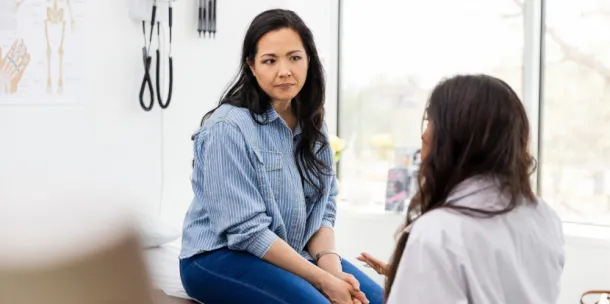 Woman listening to unrecognizable female doctor giving advice.