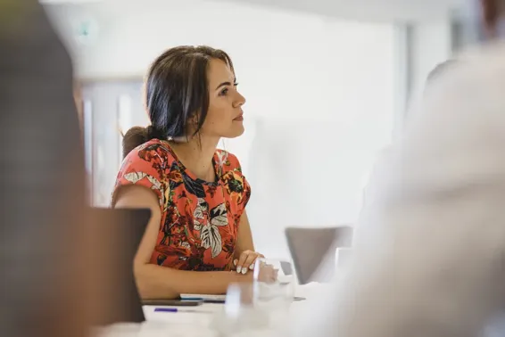 Woman sitting down in a meeting listening