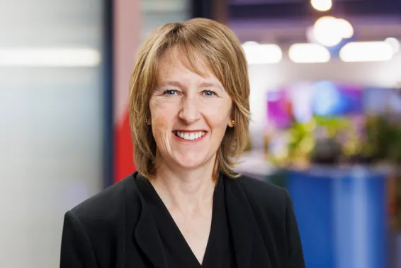 Female businesswomen with short hair to shoulder, dark suit smiling and looking at the camera