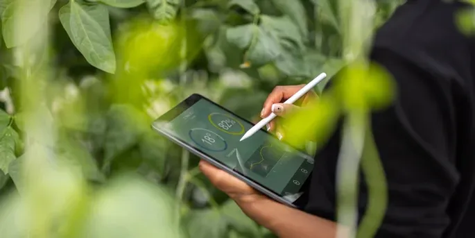 Person holding ipad and tracking data on a farm