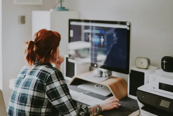 Woman sitting in front of computer looking at graphs and data