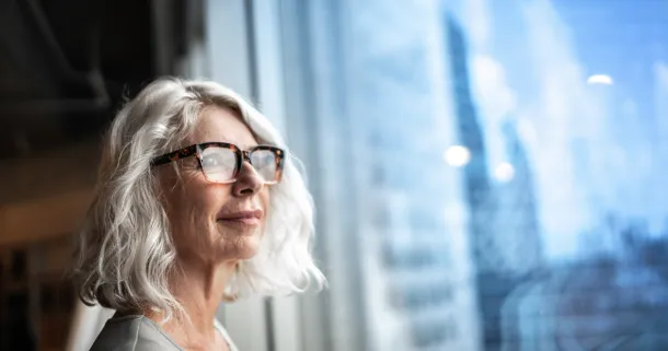 Mature businesswoman looking out of window.