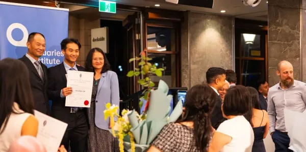 Student and family having photo taken at graduation ceremony.