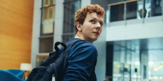 Male university student with backpack on.