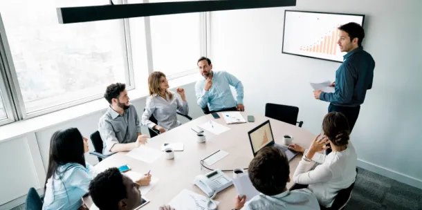 A group shot of corporate professionals discussing graphics and numbers.