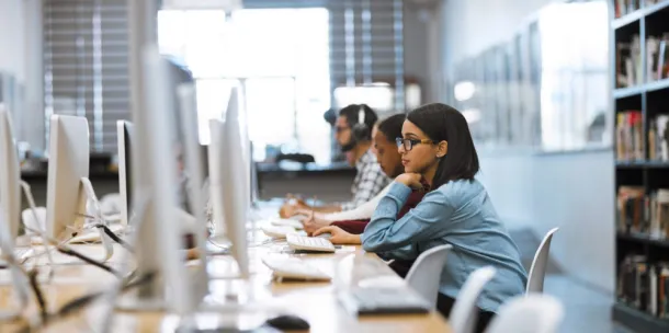 Woman in library using laptop 