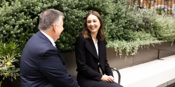 Man and a woman enjoying a laugh on a park bench