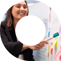 Female actuary writing on post-it-notes and pointing at whiteboard