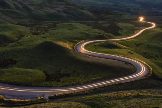 Car light trails on countryside road.