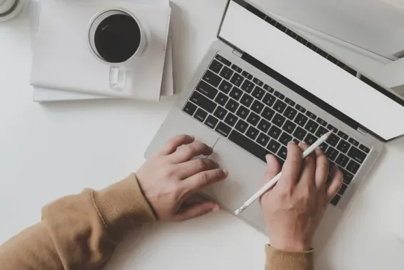 Two hands typing on a laptop