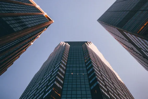 Photo looking up at tall buildings against blue sky