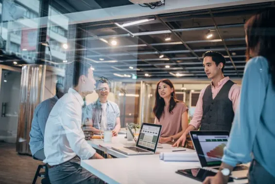 Group of people working around a desk.