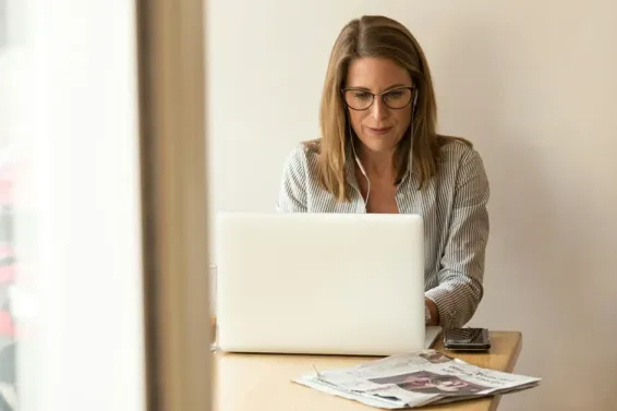 Woman with blonde hair typing on laptop
