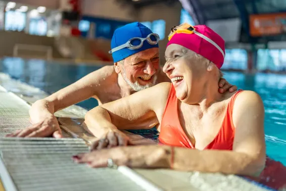 Two elderly people in the pool in swimming caps