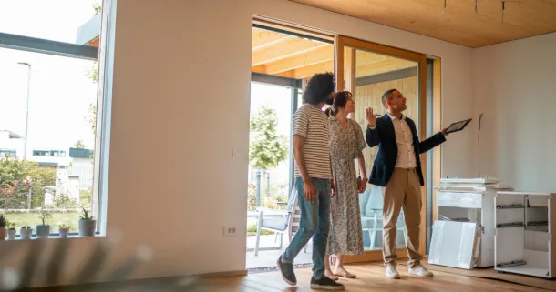 A male real estate agent engages with a couple considering potential home ownership.