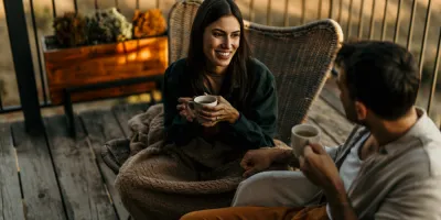 A women and man talking on the deck with a cup of tea/coffee