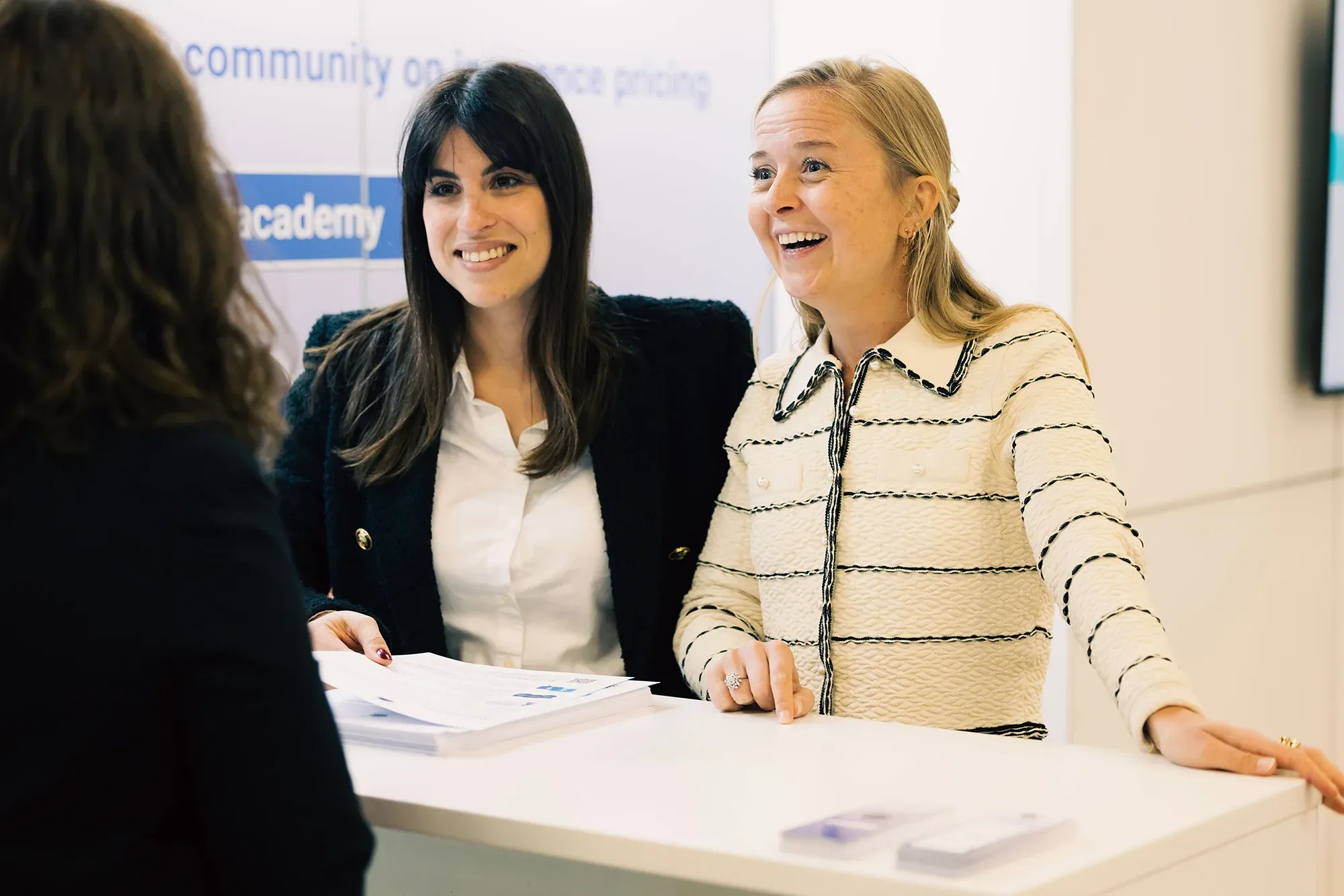 Delegate visiting two partnership program partners at a booth at conference.