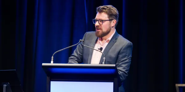 Speaker Michael Storozhev presenting from behind lectern.