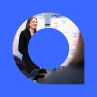 Professional woman standing in front of whiteboard and smiling.