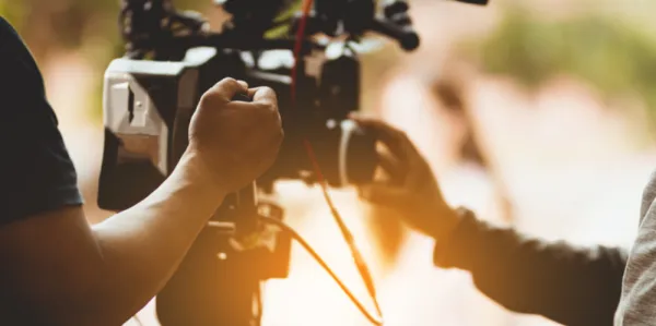 Mid section of men holding film equipment