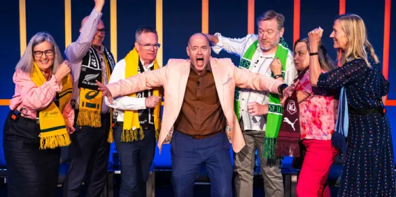 Group of speakers onstage with MC making arguing hand gestures - IDSS 2025