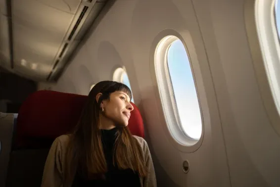 Woman looking out aeroplane window.