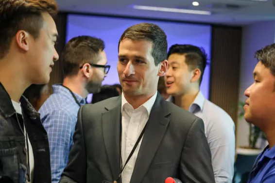 Three male young actuaries networking at an event
