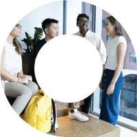 Four young actuaries standing talking to each other and networking