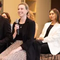 Two female actuaries in a conference room and one is holding a microphone
