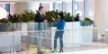 Professional man and woman stand in open office space talking