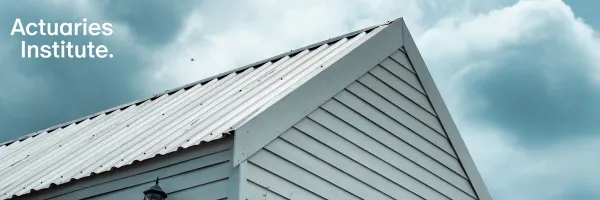 Upwards-looking image of white weatherboard house roof and cloud sky.