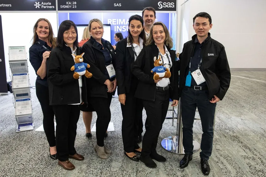 James (far back) and the SAS Team at their ICA2023 booth.