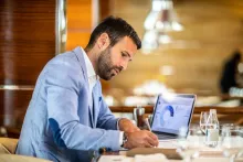 Businessman working at his desk, writing notes from a diagram