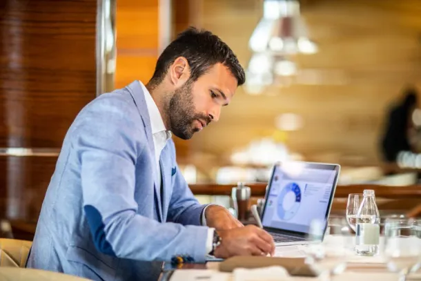 Businessman working at his desk, writing notes from a diagram