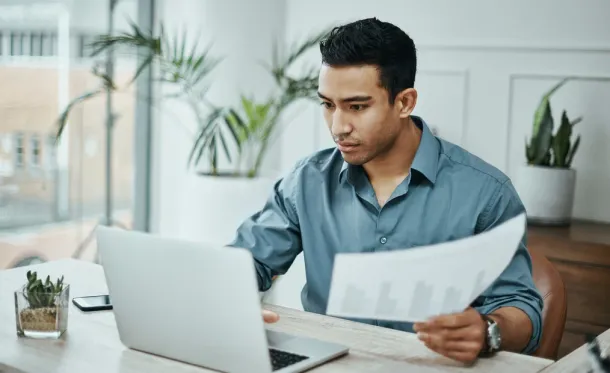 Worker looks intensely at his laptop, working on something important