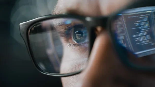 Close-up Portrait of Software Engineer Working on Computer, Line of Code Reflecting in Glasses. Developer Working on Innovative e-Commerce Application using Machine Learning, AI Algorithm, Big Data