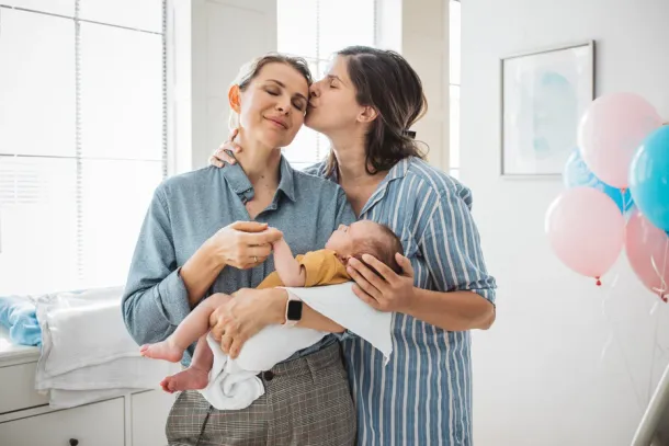 Two mothers at hospital ward holding their new born baby boy.