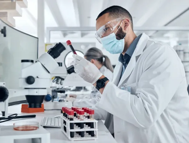 Scientist doing research using a microscope and test tube in the lab. Healthcare worker in biotechnology, medicine and analytics testing liquid in laboratory. Science man doing lab test for results