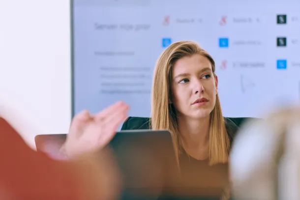 Capturing the essence of leadership and collaboration, this headshot portrait showcases a professional businesswoman attentively guiding a productive meeting with colleagues, exuding confidence and expertise.