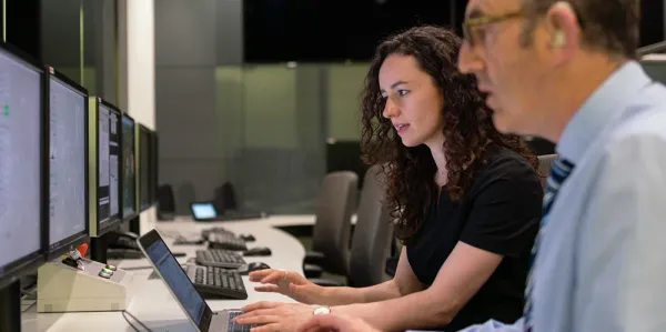 Man and a woman sitting at a computer looking at important data